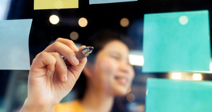 Experta mercadóloga planifica estrategia de contenidos en pizarra