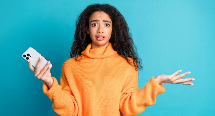 Mujer duda con celular en mano